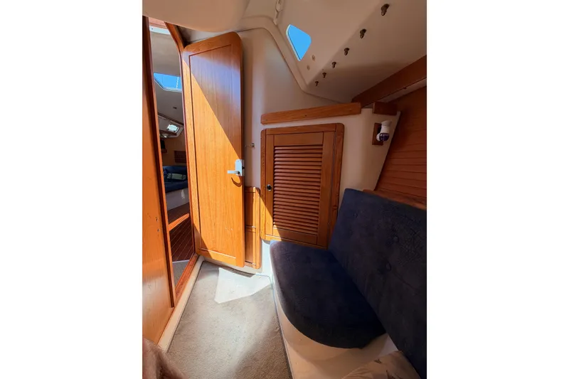 Slide: The Image of Interior of 1999 Catalina 320 sailboat with wooden door and seating area. - 35