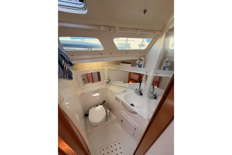 Slide: The Image of Interior of 1999 Catalina 320 sailboat bathroom with sink, toilet, and mirror. - 37