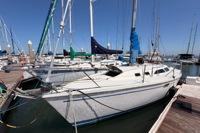 Slide: The Image of 1999 Catalina 320 sailboat docked at marina under clear blue sky. - 4