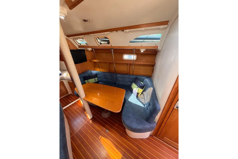 Slide: The Image of Interior of 1999 Catalina 320 sailboat with cozy seating and wooden table. - 41
