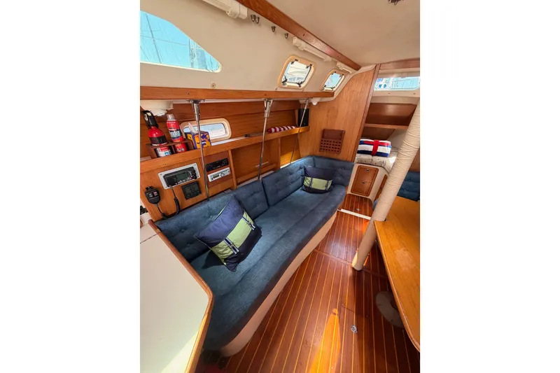 Slide: The Image of Interior of a 1999 Catalina 320 sailboat with cozy seating and wooden finishes. - 42