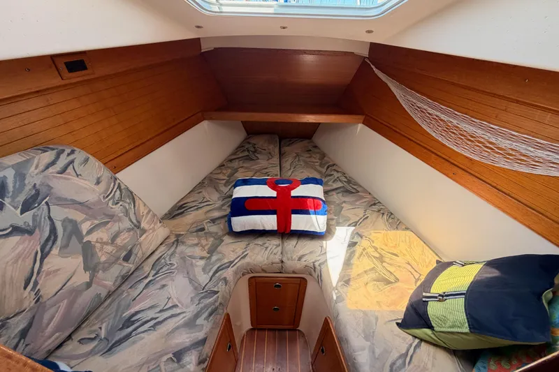 Slide: The Image of Cozy cabin interior of a 1999 Catalina 320 sailboat with patterned cushions and nautical decor. - 47