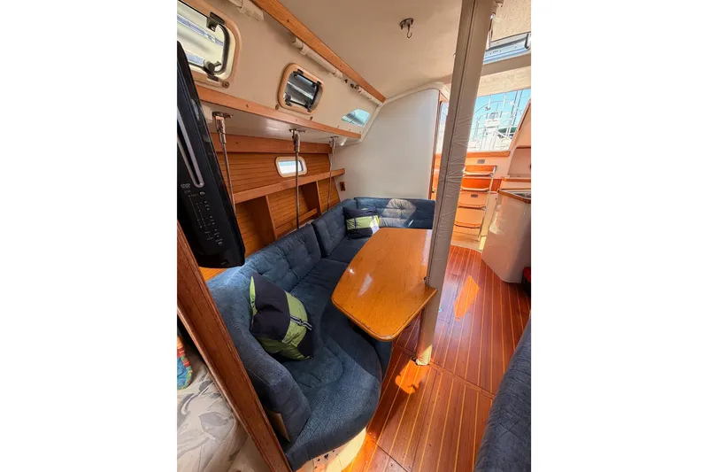 Slide: The Image of Interior of a 1999 Catalina 320 sailboat with cozy seating and wooden accents. - 48