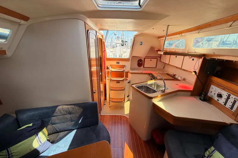 Slide: The Image of Interior of a 1999 Catalina 320 sailboat, featuring a cozy cabin with kitchen and seating area. - 50