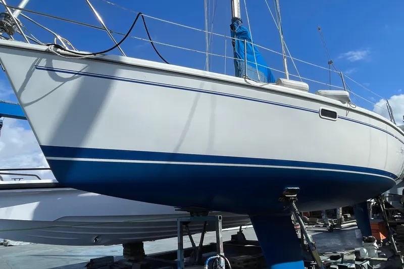 Slide: The Image of 1999 Catalina 320 sailboat on dry dock under clear blue sky. - 59