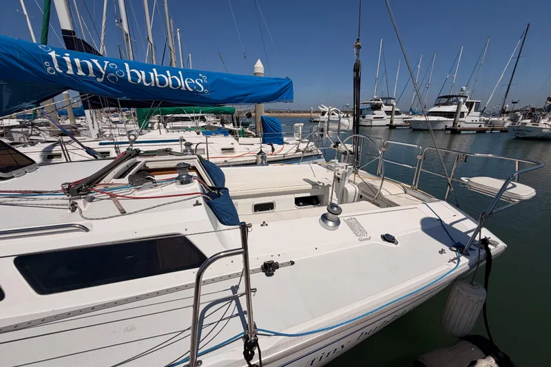 Slide: The Image of 1999 Catalina 320 sailboat docked in marina with "Tiny Bubbles" sail cover. - 6