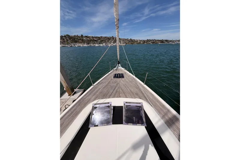 Slide: The Image of Deck view of 2020 Beneteau Oceanis 51.1 sailboat on calm waters under blue sky. - 12