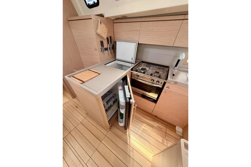 Slide: The Image of Modern kitchen in 2020 Beneteau Oceanis 51.1 yacht with stove, fridge, and wooden cabinetry. - 48