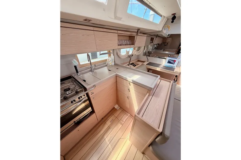 Slide: The Image of Modern kitchen interior of 2020 Beneteau Oceanis 51.1 yacht with wooden cabinetry and appliances. - 51