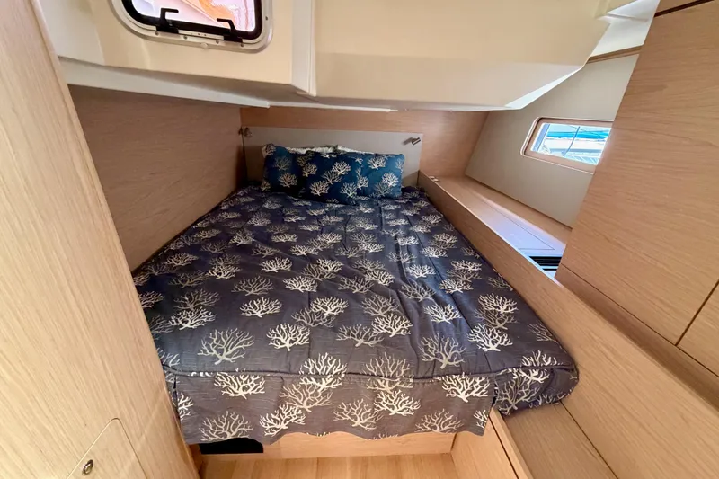 Slide: The Image of Cozy cabin interior of 2020 Beneteau Oceanis 51.1 yacht with nautical-themed bedding. - 54