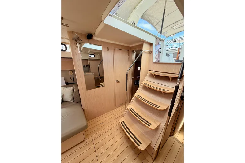 Slide: The Image of Interior of 2020 Beneteau Oceanis 51.1 yacht with wooden stairs and seating area. - 56