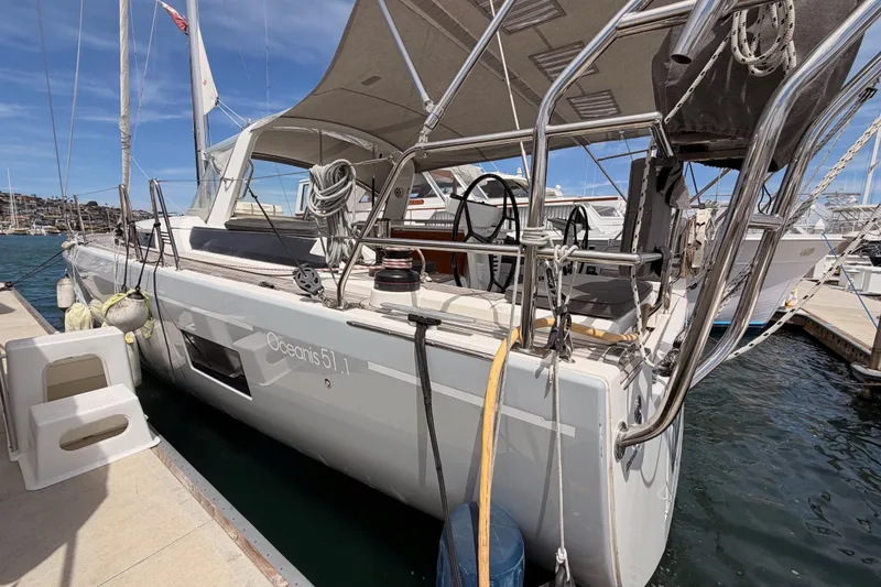Slide: The Image of 2020 Beneteau Oceanis 51.1 yacht docked at marina, showcasing sleek design and spacious deck. - 6