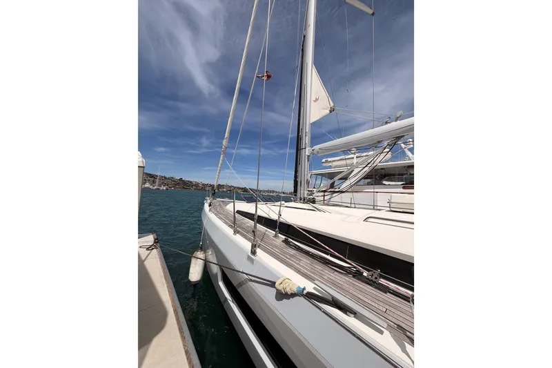 Slide: The Image of 2020 Beneteau Oceanis 51.1 yacht docked, showcasing sleek design and mast against blue sky. - 7