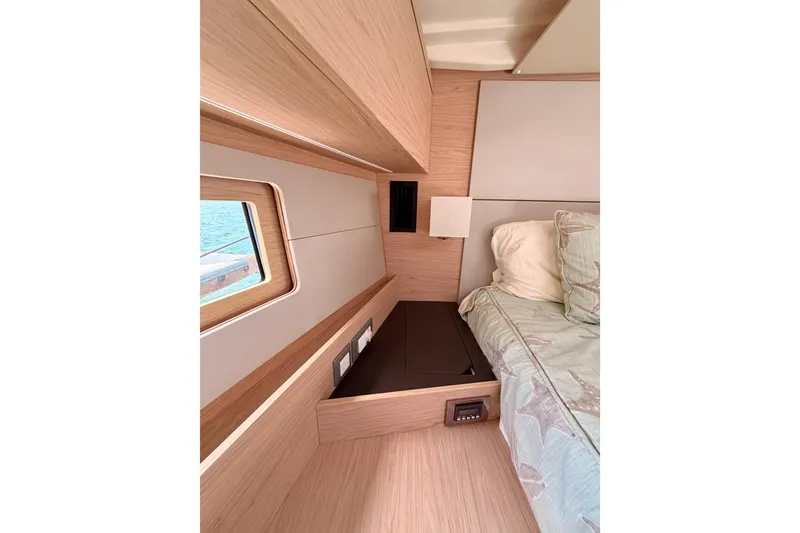 Slide: The Image of Interior cabin of 2020 Beneteau Oceanis 51.1 yacht, featuring a cozy bed and window view. - 78