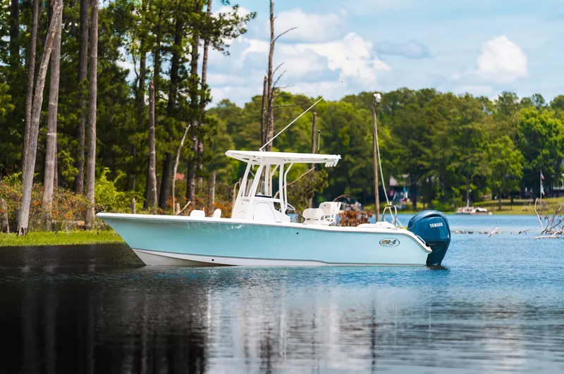 The Image of Sea Hunt Ultra 229 boat 2026 on a tranquil lake. - 1