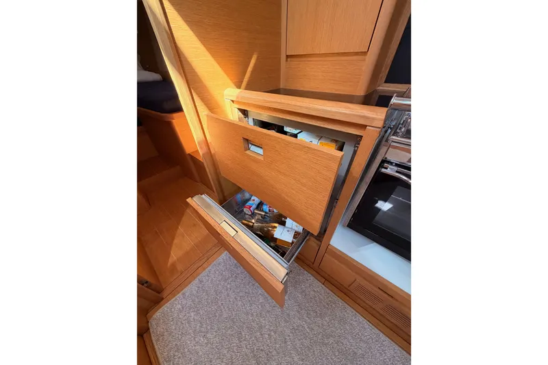 Slide: The Image of Interior of 2017 Solaris 50 yacht with open wooden cabinet and refrigerator drawer. - 67