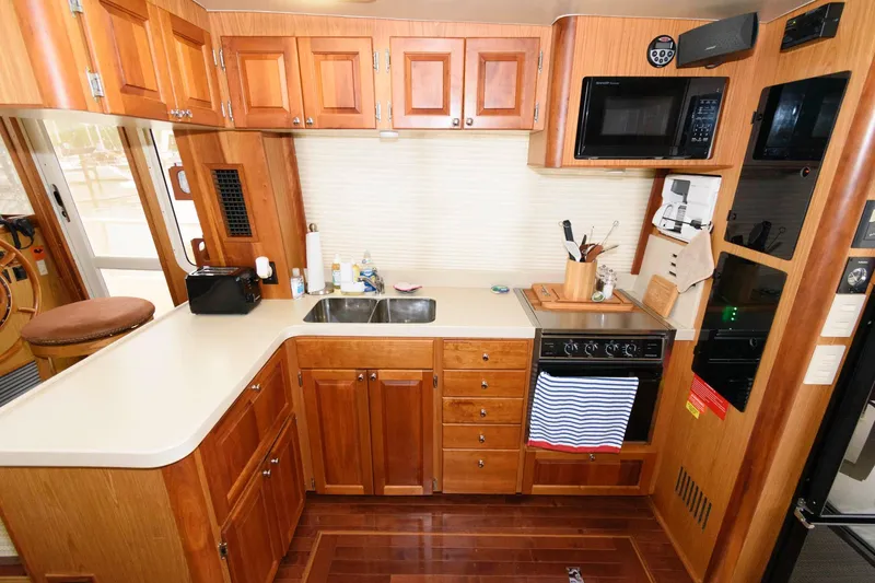 Slide: The Image of Mainship 400 Trawler 2005 kitchen with wooden cabinets and appliances. - 16