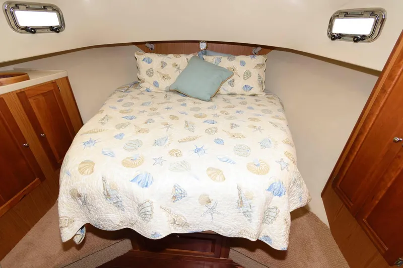 Slide: The Image of Sleeping area in 2005 Mainship 400 Trawler with nautical bedding. - 17