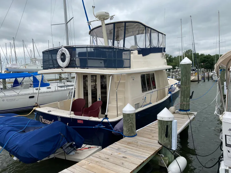Slide: The Image of 2005 Mainship 400 Trawler docked under cloudy skies. - 2