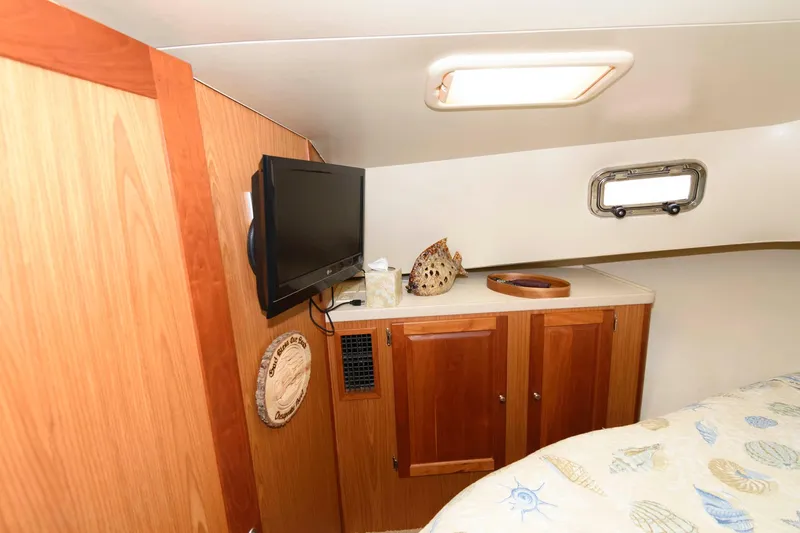 Slide: The Image of 2005 Mainship 400 Trawler cabin interior with TV and wooden cabinets. - 26