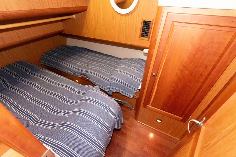 Slide: The Image of Cabin interior of 2005 Mainship 400 Trawler with twin beds and wooden finish. - 27