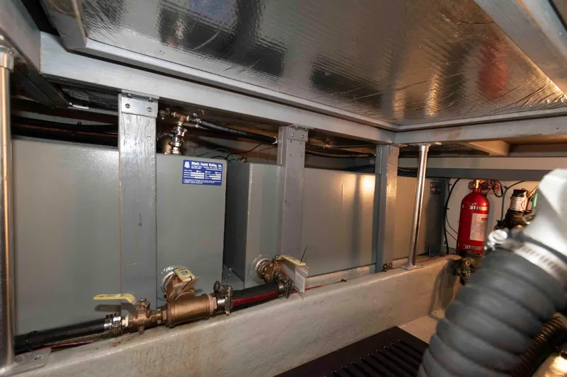 Slide: The Image of Engine room of 2005 Mainship 400 Trawler with visible fuel tanks and fire extinguisher. - 33