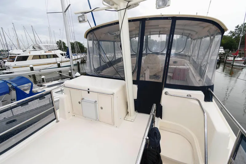 Slide: The Image of 2005 Mainship 400 Trawler at marina, featuring covered helm station. - 7