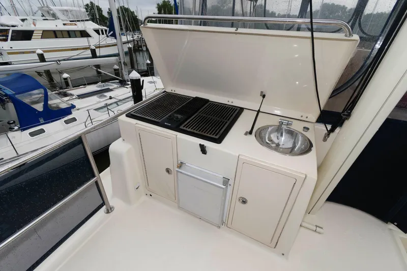 Slide: The Image of Outdoor kitchen on a 2005 Mainship 400 Trawler with grill and sink. - 9