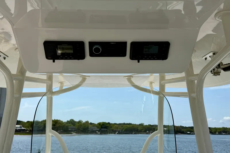 Slide: The Image of 2019 Regulator 31 boat console with Garmin and Fusion electronics, overlooking serene water. - 16