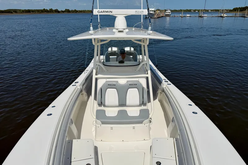Slide: The Image of 2019 Regulator 31 boat on calm water, featuring Garmin equipment and sleek seating. - 19