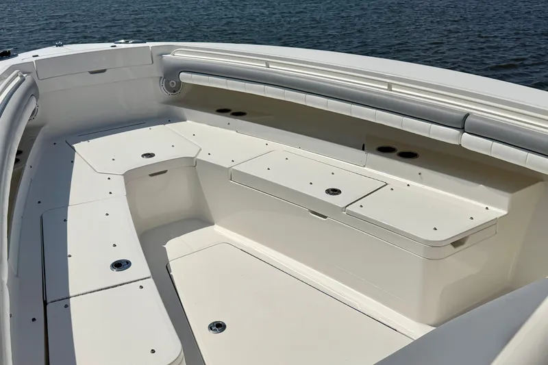 Slide: The Image of 2019 Regulator 31 boat interior with spacious seating and storage, overlooking calm water. - 21