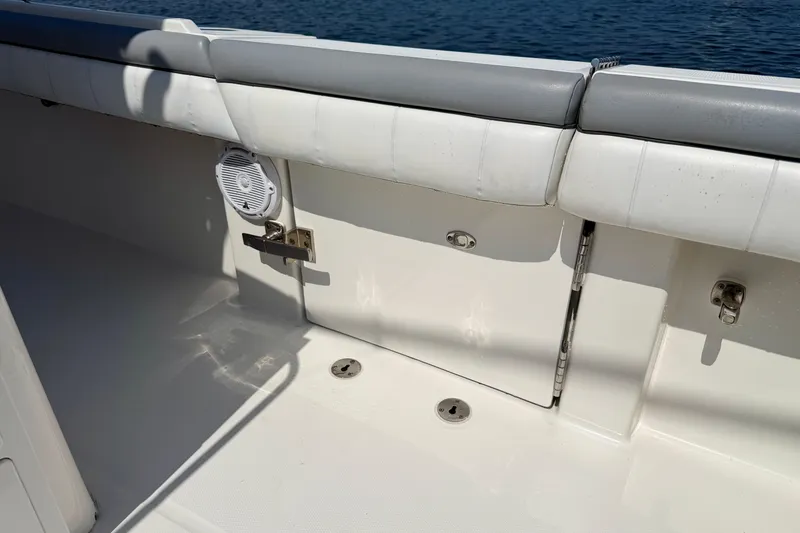 Slide: The Image of 2019 Regulator 31 boat interior with cushioned seating and speaker, near water. - 33