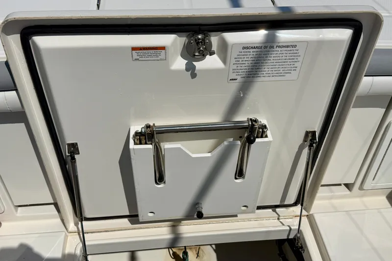 Slide: The Image of 2019 Regulator 31 boat hatch with warning labels and secure latch mechanism. - 35