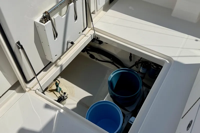 Slide: The Image of Open storage compartment on 2019 Regulator 31 boat with blue buckets inside. - 39