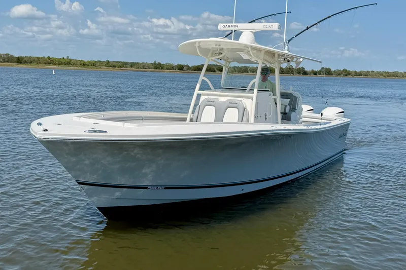 The Image of 2019 Regulator 31 boat on calm water, featuring fishing rods and Garmin equipment. - 4