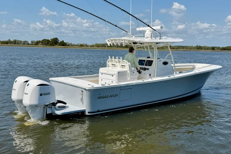 Slide: The Image of 2019 Regulator 31 boat with dual Yamaha engines on calm water. - 7