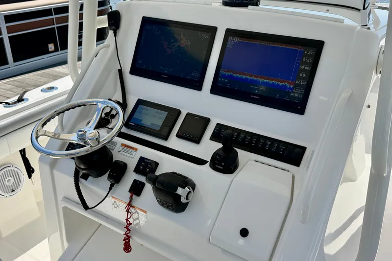 Slide: The Image of Control panel of a 2019 Regulator 31 boat with navigation screens and steering wheel. - 8