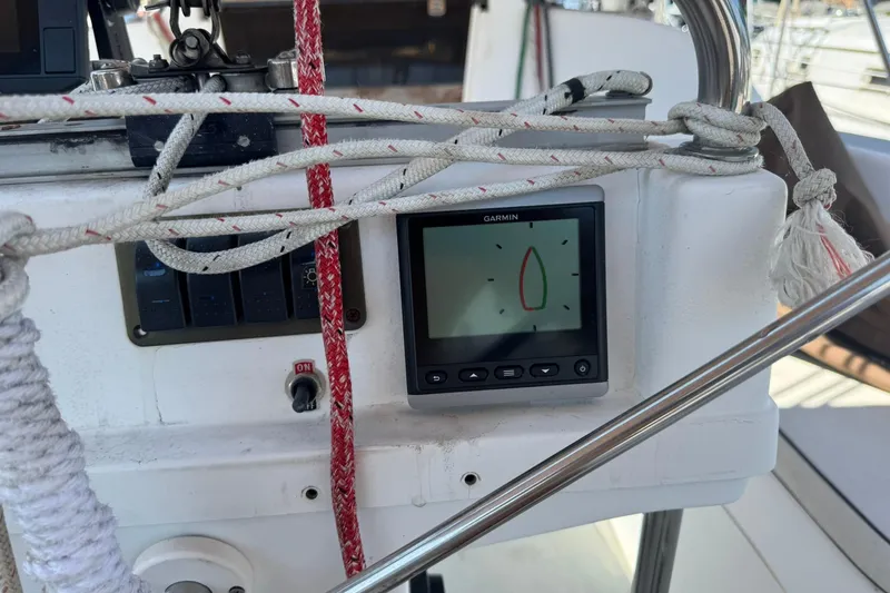 Slide: The Image of Garmin navigation display on 1994 Hunter 29.5 sailboat cockpit, surrounded by ropes and controls. - 13