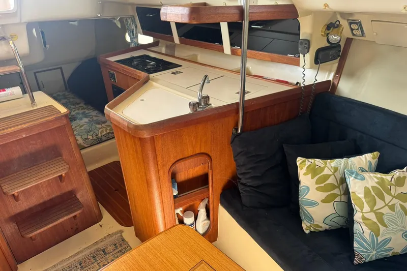 Slide: The Image of Interior of a 1994 Hunter 29.5 sailboat with cozy seating and compact kitchen area. - 18