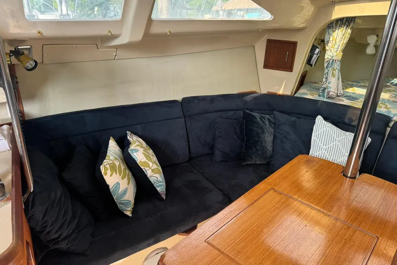 Slide: The Image of Interior of a 1994 Hunter 29.5 sailboat with cozy seating and decorative pillows. - 19