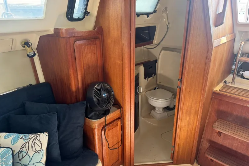 Slide: The Image of Interior of a 1994 Hunter 29.5 sailboat featuring a compact bathroom and cozy seating area. - 21