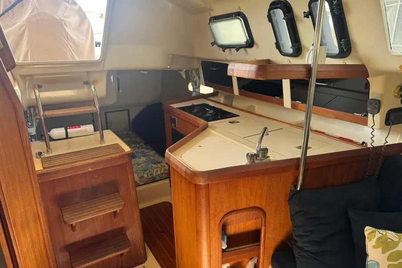 Slide: The Image of Interior of a 1994 Hunter 29.5 sailboat with wooden cabinetry and compact kitchen. - 23