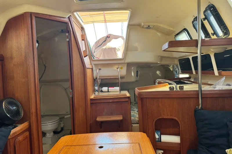 Slide: The Image of Interior of a 1994 Hunter 29.5 sailboat, featuring wood cabinetry and compact living space. - 24
