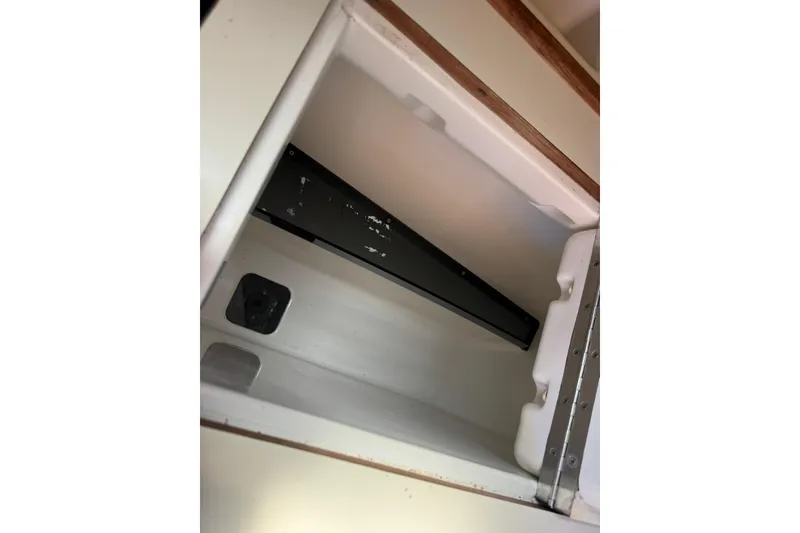 Slide: The Image of Interior compartment of a 1994 Hunter 29.5 boat, featuring storage space and electrical outlet. - 28