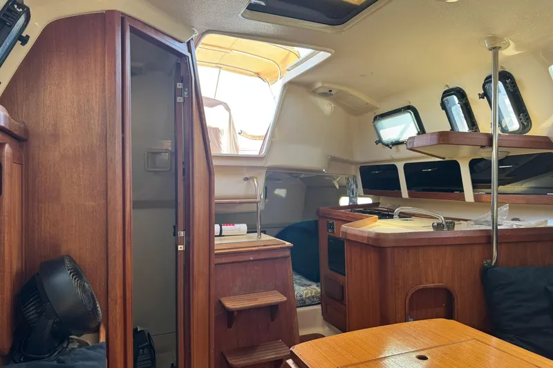 Slide: The Image of Interior of 1994 Hunter 29.5 sailboat with wood finish and compact kitchen area. - 30