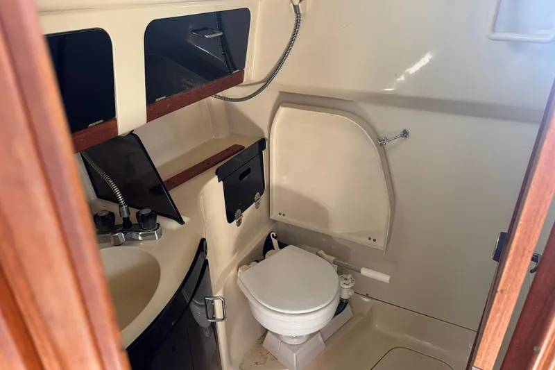 Slide: The Image of 1994 Hunter 29.5 sailboat bathroom with sink, toilet, and storage compartments. - 34