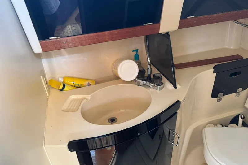 Slide: The Image of Compact bathroom sink area in a 1994 Hunter 29.5 sailboat, featuring toiletries and storage. - 35