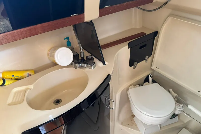 Slide: The Image of 1994 Hunter 29.5 yacht bathroom with sink, toilet, and toiletries. - 36