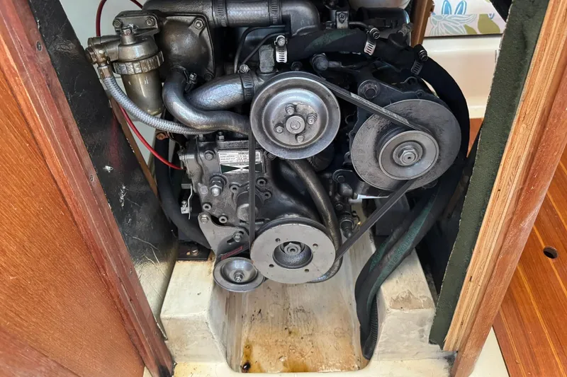 Slide: The Image of Engine compartment of a 1994 Hunter 29.5 sailboat, showcasing mechanical components and belts. - 38