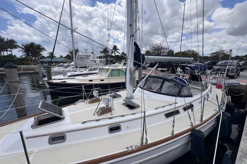The Image of 1981 Gulfstar 44 Mk II Center Cockpit Sloop docked at marina under cloudy sky. - 0